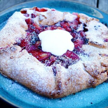 Blomme og brombær galette serveret med cremefraiche