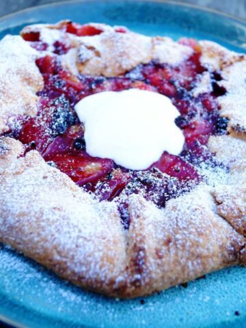 Blomme og brombær galette serveret med cremefraiche