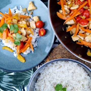 Wok ret med kylling, ris og grøntsager på spisebord