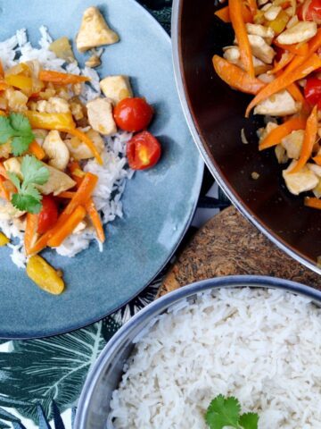 Wok ret med kylling, ris og grøntsager på spisebord